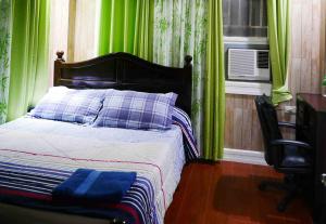 - une chambre avec un lit doté de rideaux verts et d'une fenêtre dans l'établissement JMTヴィラ, à Dinalupihan