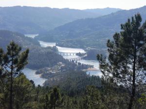 vistas a un puente sobre un río con árboles en Casa Feijao - Alojamento Local, en Gerês