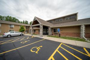 a car parked in a parking lot in front of a building at AmericInn by Wyndham Ames in Ames