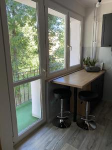 eine Küche mit einem Holztisch und 2 Fenstern in der Unterkunft Broniewskiego Centrum Konin in Konin