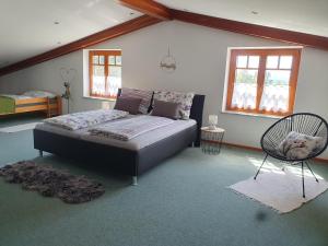 a bedroom with a bed and a chair in it at Ferienhaus Panorama in Rechnitz