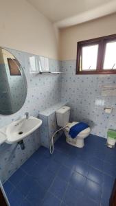 a blue tiled bathroom with a toilet and a sink at Panupong Hotel in Chaweng