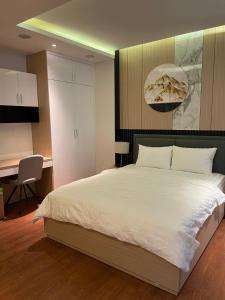 een slaapkamer met een groot wit bed en een bureau bij Nikko Hotel - The Classy Life in Ho Chi Minh-stad