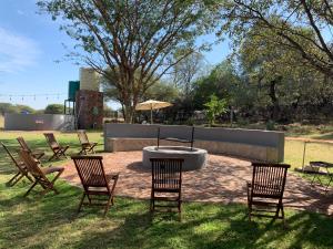 a group of chairs sitting around a table in the grass at Tula Baba Game Lodge in Brits