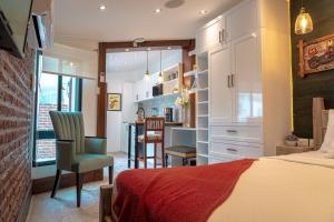 1 dormitorio con 1 cama y cocina con mesa en Praga Apartamentos Guayaquil Urdesa, en Guayaquil