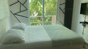 1 dormitorio con 1 cama grande y ventana en Book House Marina Diamante, en Acapulco