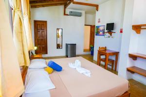 sypialnia z białym łóżkiem i ręcznikami w obiekcie Galapagos Verde Azul w mieście Puerto Ayora