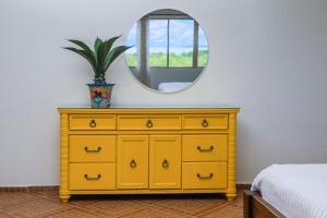 Vestidor amarillo en un dormitorio con espejo en El Regalo Resort, en Boca Chica