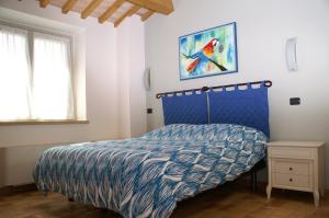 a bedroom with a bed with a blue and white comforter at Ca' Lupino in Urbino