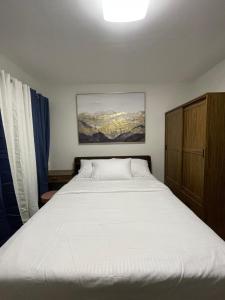 a bedroom with a large white bed in it at FLY & REST GUESTHOUSE - Mactan-Cebu International Airport in Lapu Lapu City