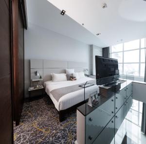 a bedroom with a bed and a television in it at S31 Sukhumvit Hotel in Bangkok