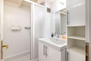 um banheiro branco com pia e chuveiro em Historic Apartment em Praga