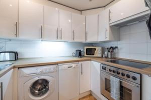 uma cozinha com armários brancos e uma máquina de lavar louça em Historic Apartment em Praga mais 14 fotografias