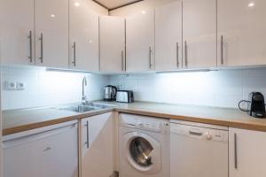 uma cozinha com armários brancos e uma máquina de lavar roupa em Historic Apartment em Praga
