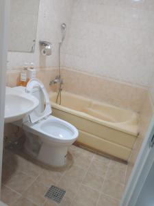 a bathroom with a toilet and a sink and a tub at T stay guesthouse in Cheongju