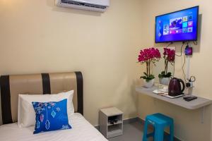 - une chambre avec un lit et une télévision murale dans l'établissement Southern Tip Hotel, à Pontian Kecil
