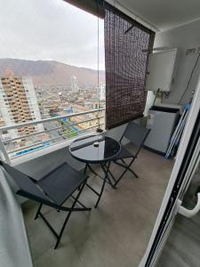Habitación con mesa, sillas y ventana grande. en EDIFICIO LYNCH CENTRO IQUIQUE, en Iquique