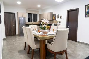 cocina y comedor con mesa y sillas en Praga Apartamentos Guayaquil Urdesa, en Guayaquil