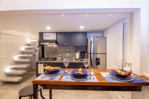 a kitchen with a wooden table with plates and wine glasses at Praga Apartamentos Guayaquil Urdesa in Guayaquil