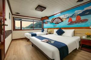 Un dormitorio con dos camas y un cuadro en la pared. en Fantasea Imperial Cruise, en Ha Long