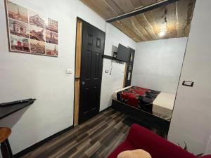 Habitación con dormitorio con cama y puerta en Poas Volcano Rooms, en Fraijanes