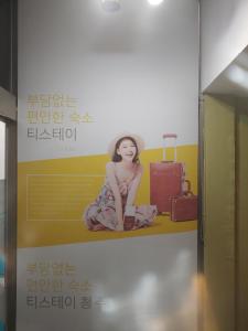 a poster of a woman sitting on a shelf with luggage at T stay pension in Cheongju