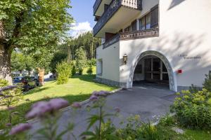 a house with a driveway and a yard with flowers at Chasa Valambrun 1004 in Vulpera