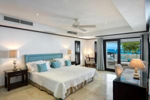 ein Schlafzimmer mit Bett und ein Wohnzimmer in der Unterkunft Coral Cove 7 - Sunset Blue Sky Luxury in Saint James