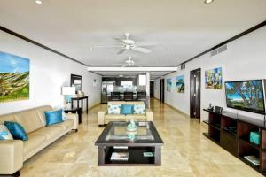 ein Wohnzimmer mit Sofa und Fernseher in der Unterkunft Coral Cove 7 - Sunset Blue Sky Luxury in Saint James + 22 Fotos