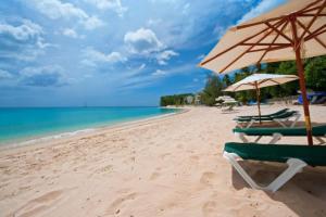 a beach with two chairs and an umbrella and the ocean at Coral Cove 7 - Sunset Blue Sky Luxury in Saint James