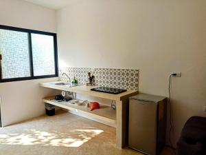 eine Küche mit einer Theke, einem Waschbecken und einem Fenster in der Unterkunft XAMANA Holbox in Holbox