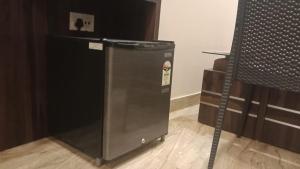 una nevera negra en una habitación junto a una mesa en Hotel Bani Hashim 110 Mtrs from Dargah, en Ajmer