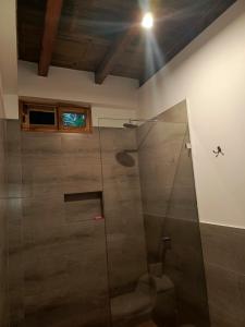 La salle de bains est pourvue d'une douche avec une porte en verre. dans l'établissement Casa Happy Beach Ayampe, à Puerto López