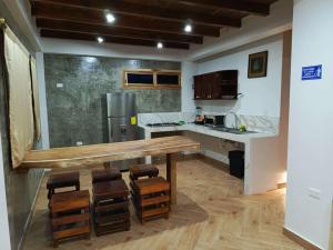 a kitchen with a wooden table and some chairs at Casa Happy Beach Ayampe in Puerto López