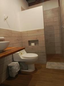 een badkamer met een wit toilet en een wastafel bij Casa Happy Beach Ayampe in Puerto López