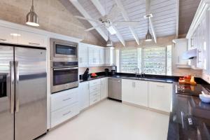 a kitchen with white cabinets and stainless steel appliances at Todmorden by Blue Sky Luxury in Saint Peter