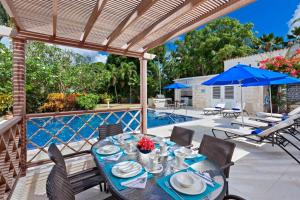 a patio with a table and chairs and a pool at Todmorden by Blue Sky Luxury in Saint Peter