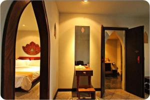 a hotel room with a bed and a mirror at Gudi Boutique Hotel in Mae Rim