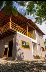 une petite maison avec un grand toit dans l'établissement Casa Happy Beach Ayampe, à Puerto López