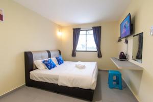 Schlafzimmer mit einem großen Bett und einem Fenster in der Unterkunft Southern Tip Hotel in Pontian Kecil