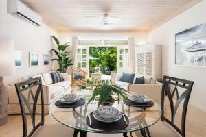 a living room with a glass table and chairs at Beacon Hill 202 - Moonshadow by Blue Sky Luxury in Saint Peter