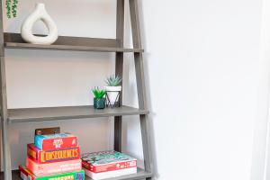 a ladder shelf with books and a stack thereof at City Centre 3 Bed 8 Guest Parking Near Mayflower in Southampton