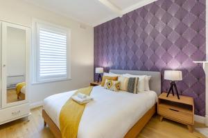 ein Schlafzimmer mit einem großen Bett mit einer lila Wand in der Unterkunft Sydney CBD stylish water view apartment 58 in Sydney
