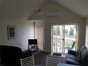 a living room with a couch and a tv at Bayview Apartments in Merimbula
