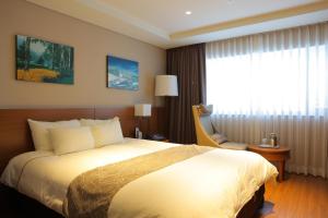 um quarto de hotel com uma cama grande e uma janela em Yongpyong Resort em Pyeongchang