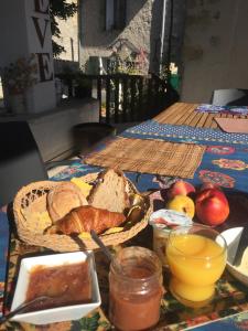 una mesa cubierta con una cesta de pan y manzanas en La Maison des Soleils en Soleilhas