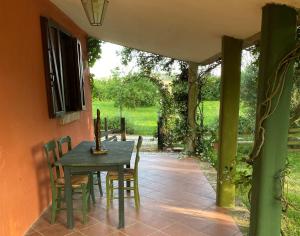 una mesa y sillas en un patio con puerta abierta en Cottage Oasi di San Martino, en San Martino in Colle