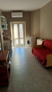 sala de estar con cama roja y cocina en Alloggio turistico Garibaldi, en Viterbo