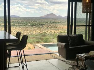 ein Wohnzimmer mit einem Sofa und Blick auf die Wüste in der Unterkunft LEOPARD'S VIEW MOUNTAIN VILLA @ Steinheim Game Farm & Camping in Prospect