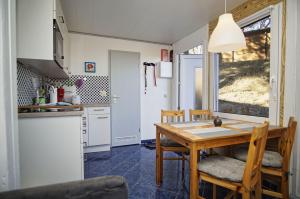 a kitchen and dining room with a table and chairs at Dünenchalet Nr 49 in Göhren
